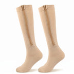 Pair of beige Calmyo zip-up compression socks for flying, zip running ankle to knee